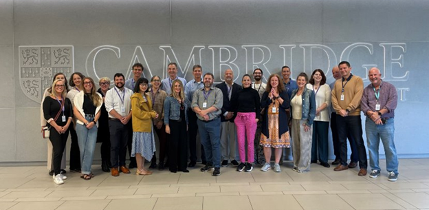 The Cambridge North America team standing in front of the Cambridge sign in the UK